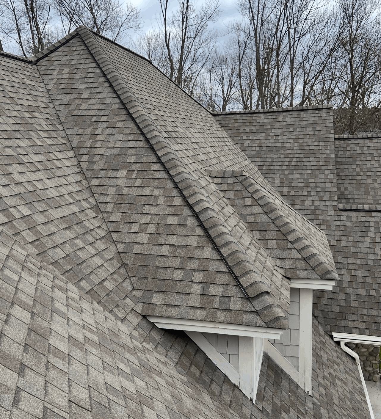 Architectural asphalt shingle roof with hip and ridge caps over a dormer