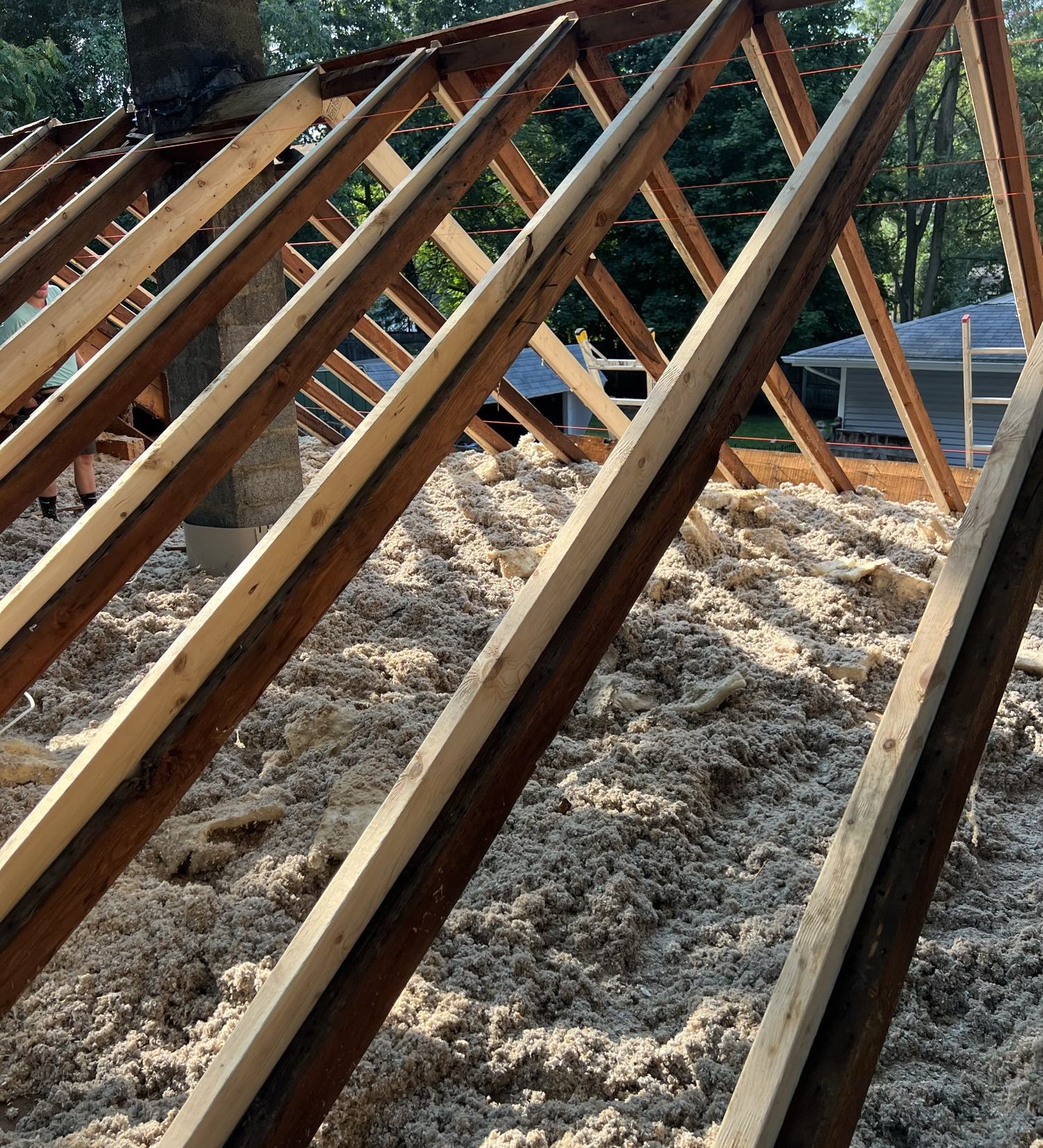 Roof stripped to the rafters with new lumber fastened alongside the old framing